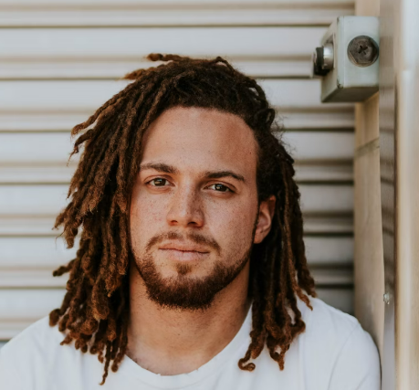 Man with dreadlocks in white shirt